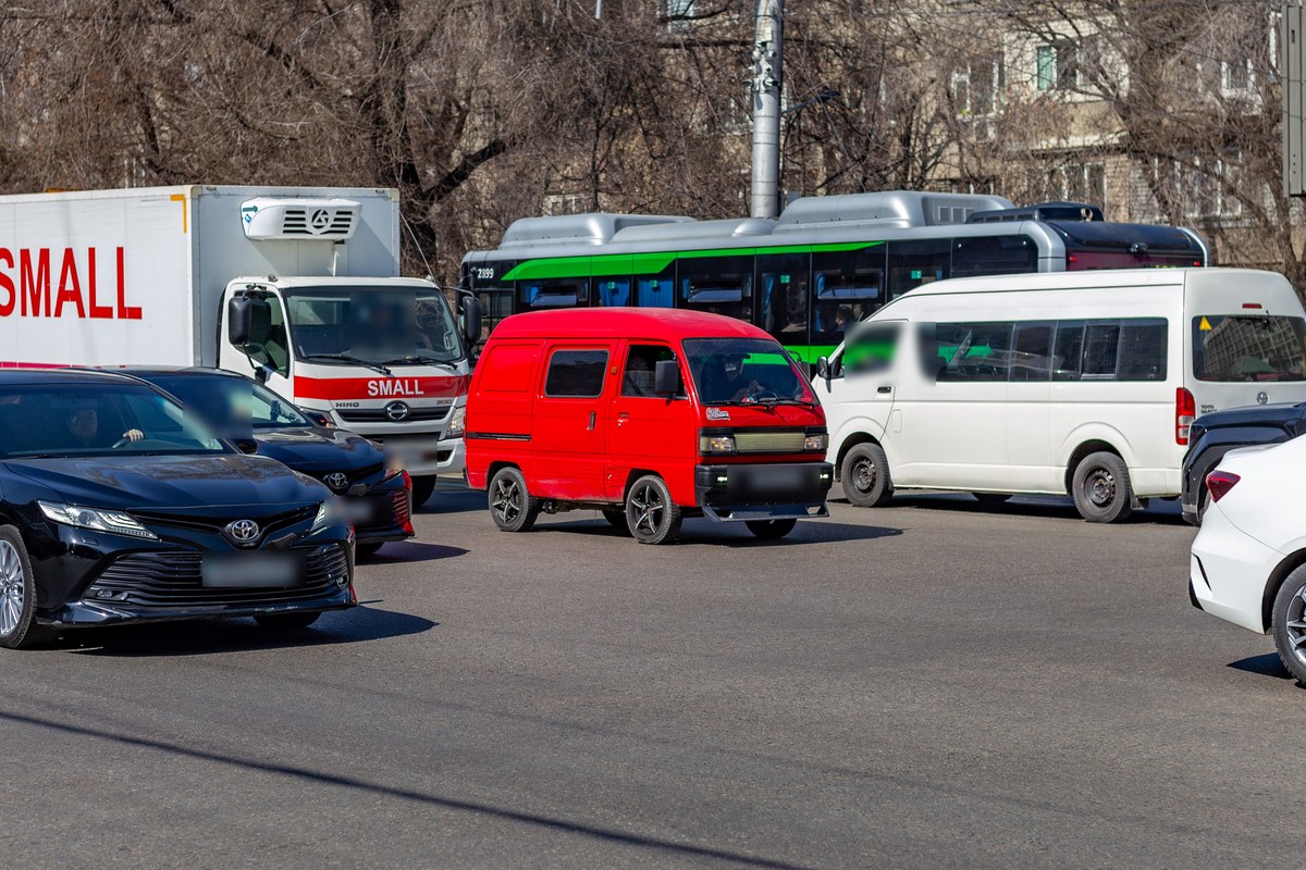 Красный Daewoo Damas в потоке на перекрёстке в Алматы