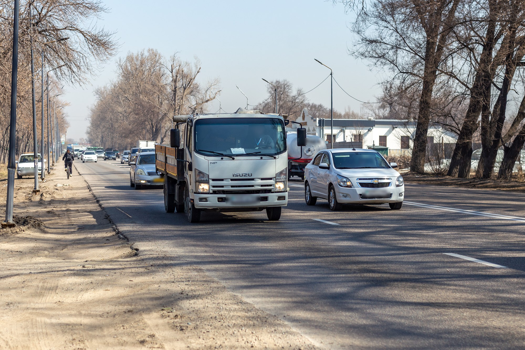 Движение на Кульджинском тракте в Алматы, легковой автомобиль рядом с грузовиком
