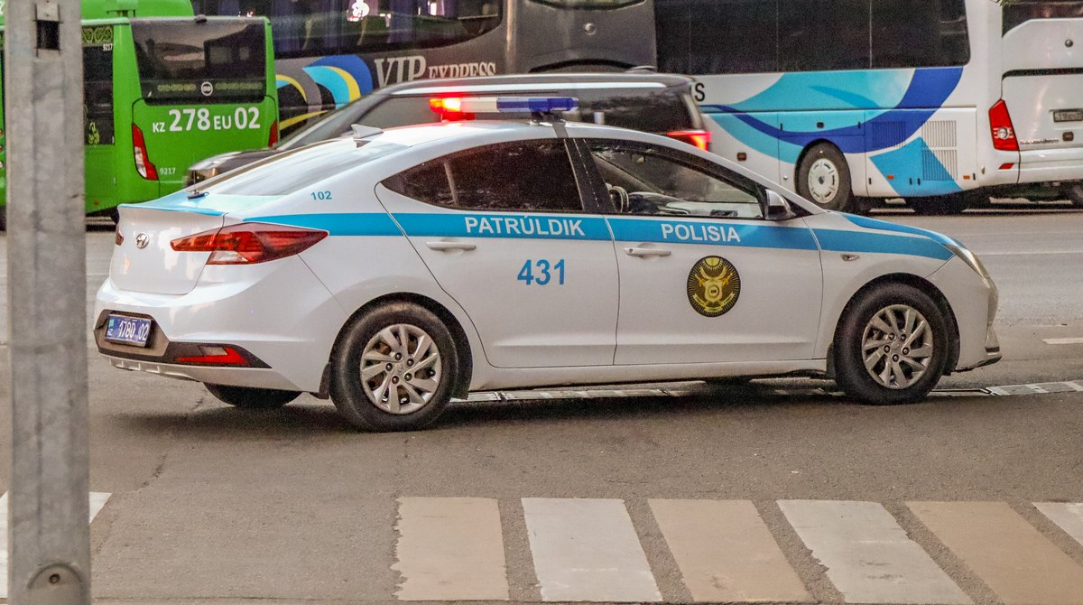 Патрульная машина полиции у пешеходного перехода в Алматы