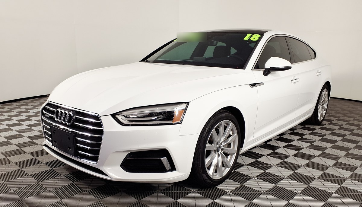 Белый Audi A5 Sportback, вид спереди слева, в помещении дилера