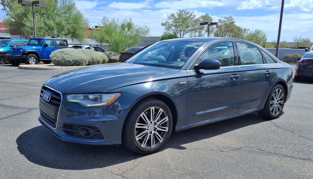 Серо-синий седан Audi A6 C7 до рестайлинга, вид спереди слева, на стоянке