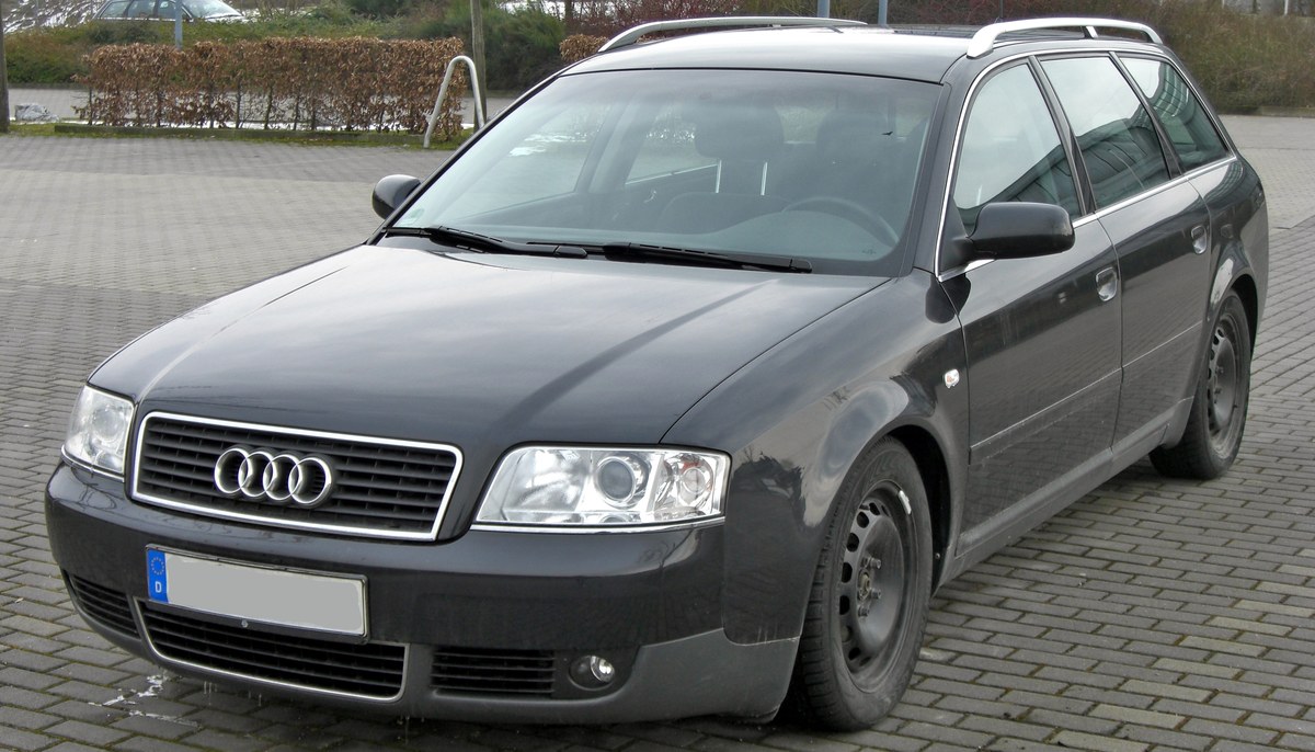 Тёмно-серый Audi A6 Avant C5, вид спереди слева в три четверти, на брусчатке