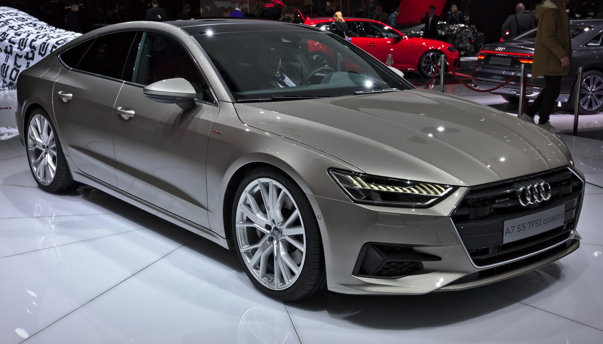 Серо-бежевый Audi A7 Sportback на выставке, вид спереди справа