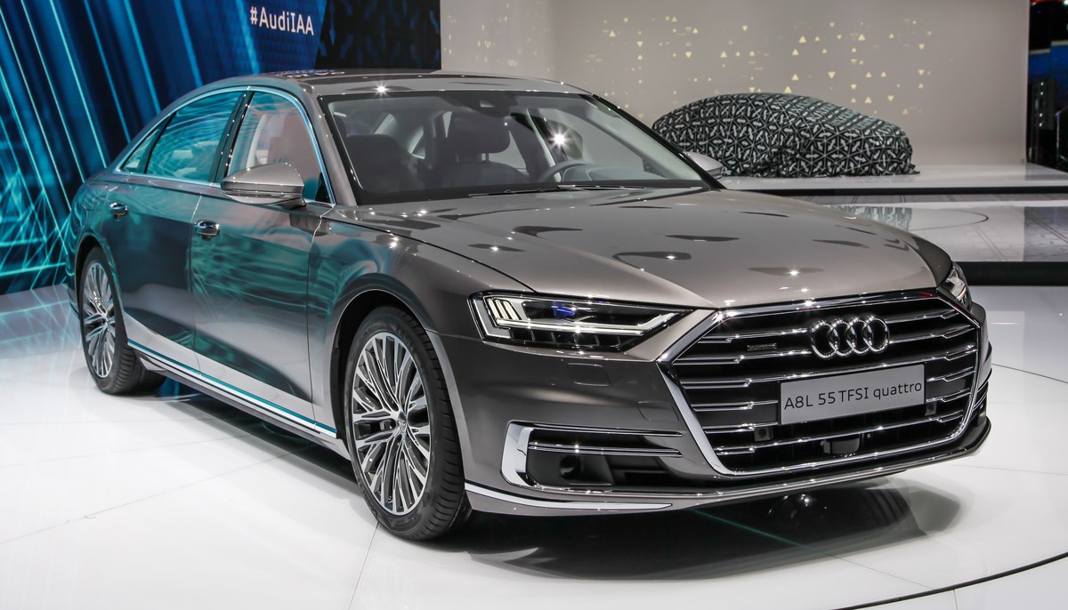 Серо-коричневый Audi A8 L пятого поколения на выставочном стенде, вид спереди справа