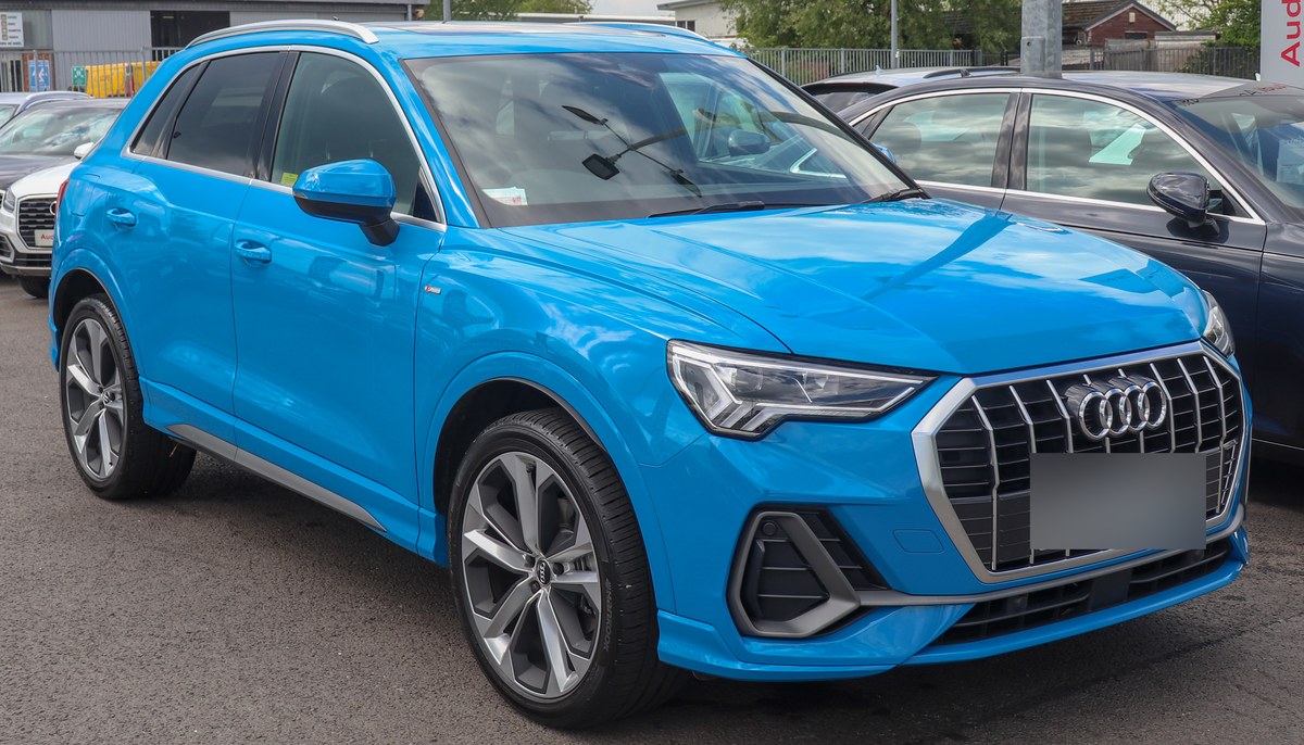 Голубой Audi Q3 второго поколения S line, вид спереди справа, на стоянке дилера