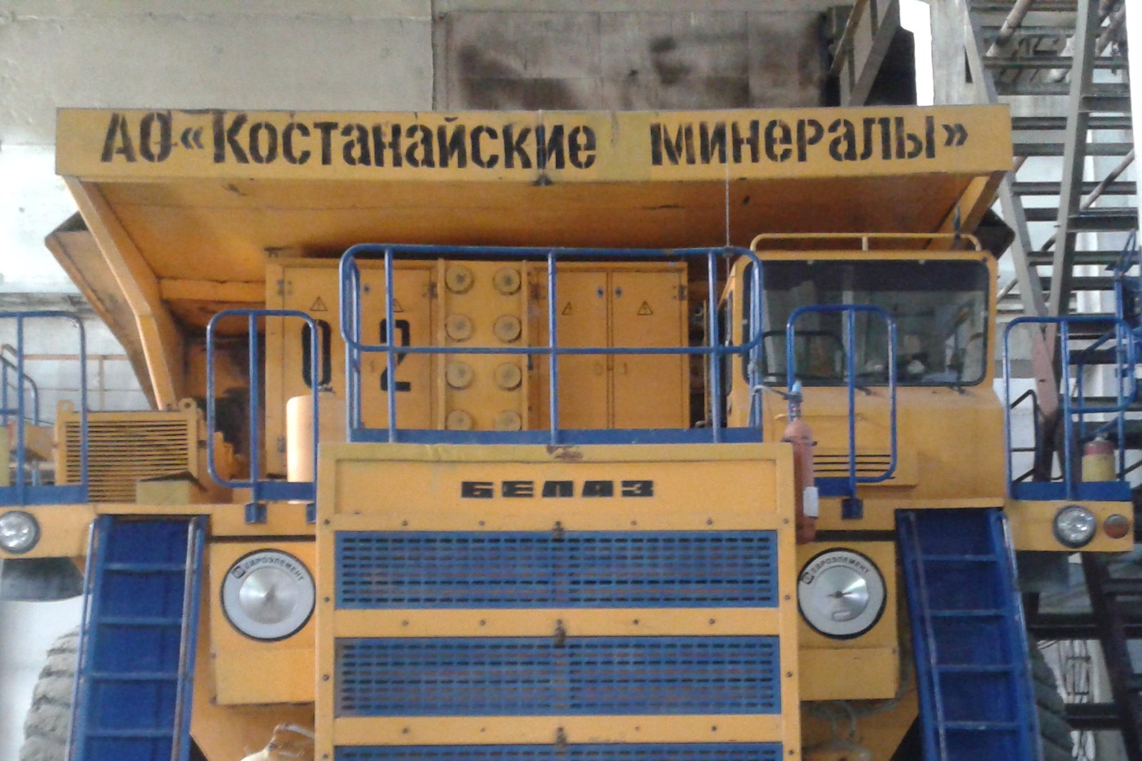 Жёлтый карьерный самосвал БелАЗ с надписью на кузове