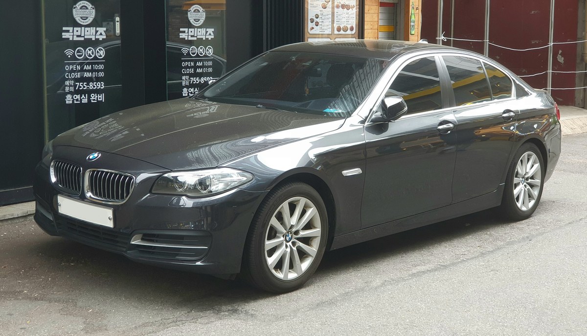 BMW 5 серии F10 седан в тёмно-сером цвете, вид спереди сбоку