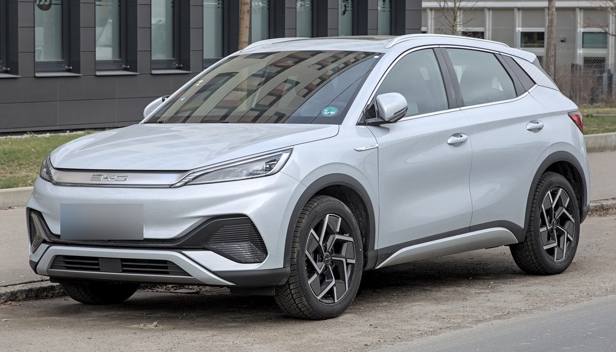 Серебристый электрокроссовер BYD Atto 3, вид спереди в три четверти слева, на городской улице