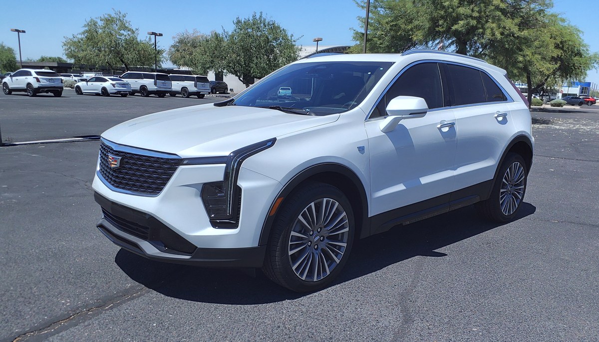 Белый Cadillac XT4 Premium Luxury, вид спереди слева в три четверти, на парковке дилера