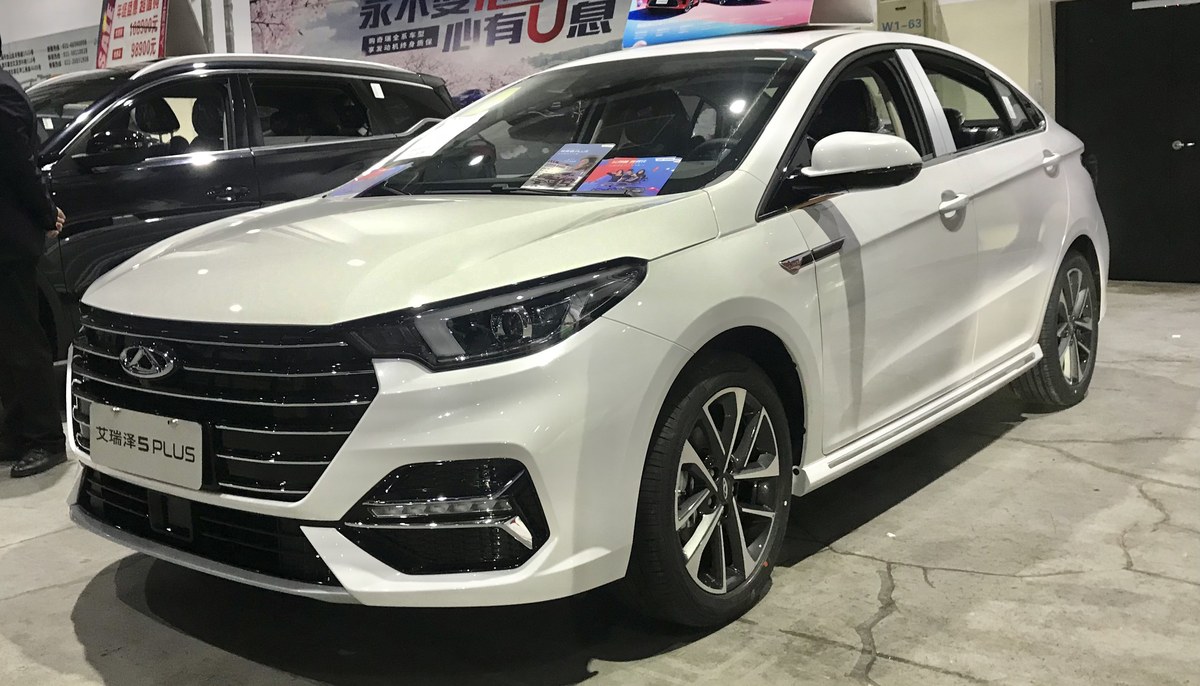 Белый седан Chery Arrizo 5 Plus (в Казахстане Arrizo 6), вид спереди в выставочном зале
