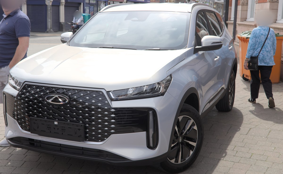Серебристый Chery Tiggo 7 второго поколения, вид спереди справа, на пешеходной улице