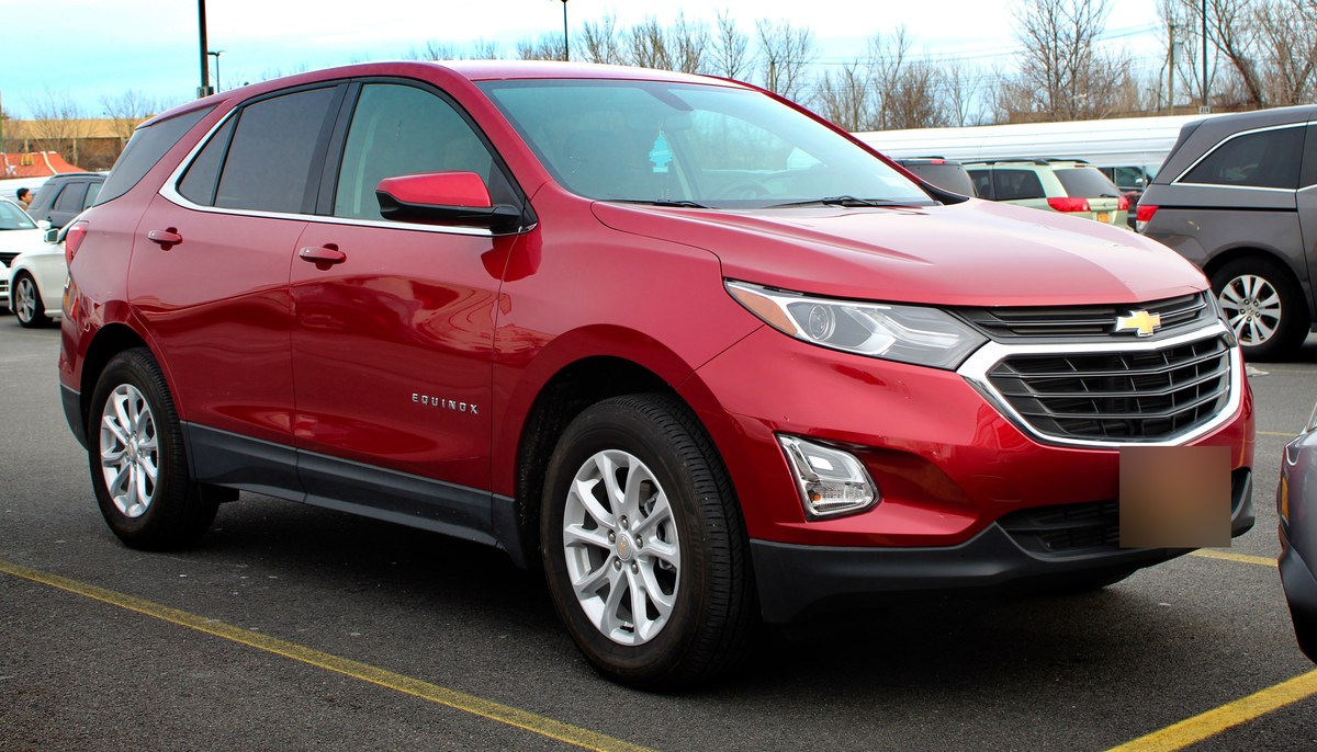Красный кроссовер Chevrolet Equinox LT, вид спереди справа, на городской улице