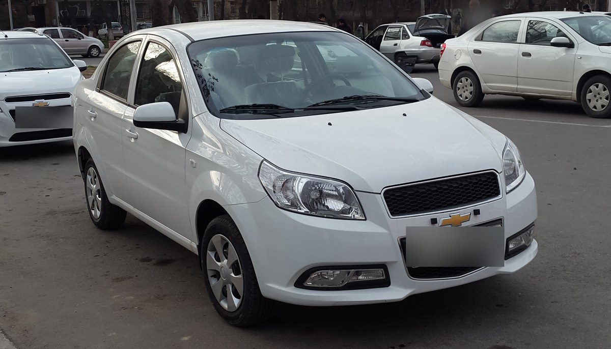 Белый седан Chevrolet Nexia R3 (Nexia 3) на парковке в Ташкенте, вид спереди сбоку