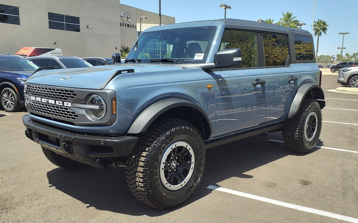 Голубой четырёхдверный Ford Bronco Badlands на стоянке, вид спереди