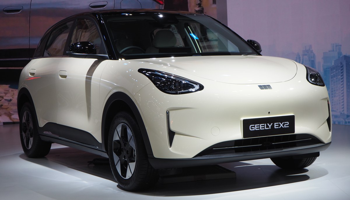Электрохэтчбек Geely EX2 (Galaxy E2) в кремовом цвете с чёрной крышей, вид спереди справа, автосалон в Таиланде