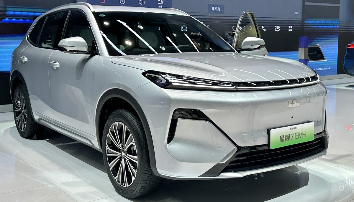 Серебристый подключаемый гибридный кроссовер Geely Galaxy Starship 7 EM-i, вид спереди в три четверти, на выставке