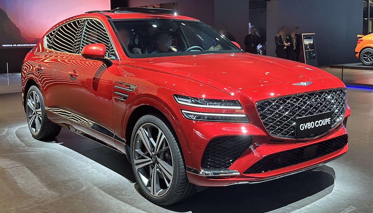 Красный Genesis GV80 Coupe с покатой крышей, вид спереди в три четверти, на выставочном стенде