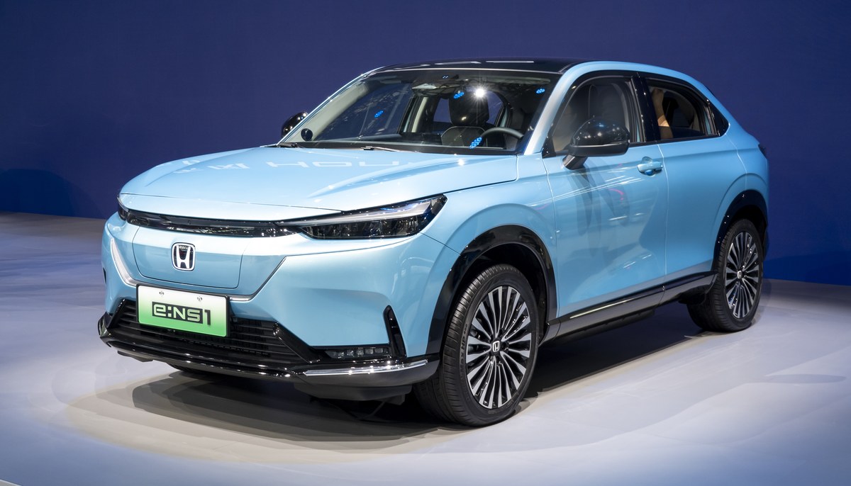 Голубой электрокроссовер Dongfeng Honda e:NS1 на выставочном подиуме, вид спереди слева в три четверти