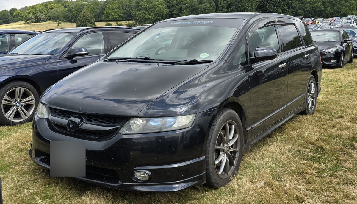Чёрная Honda Odyssey третьего поколения (RB1) с обвесом, вид спереди слева в три четверти