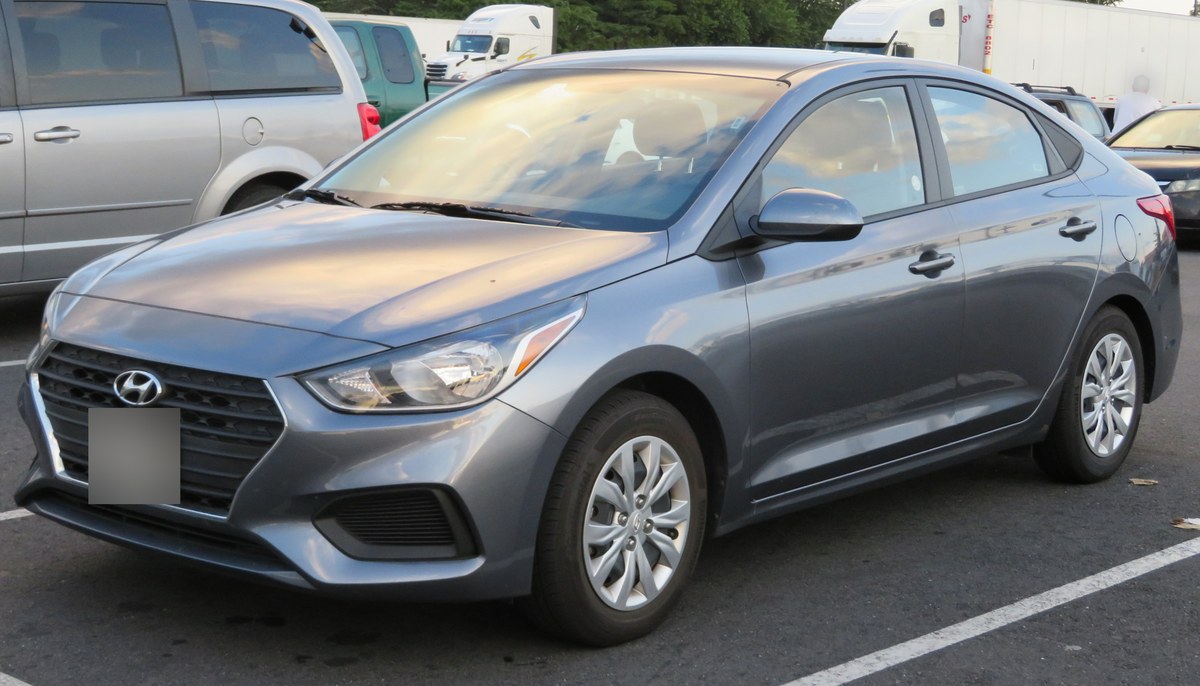 Белый седан Hyundai Accent HC до рестайлинга, вид спереди слева, на парковке