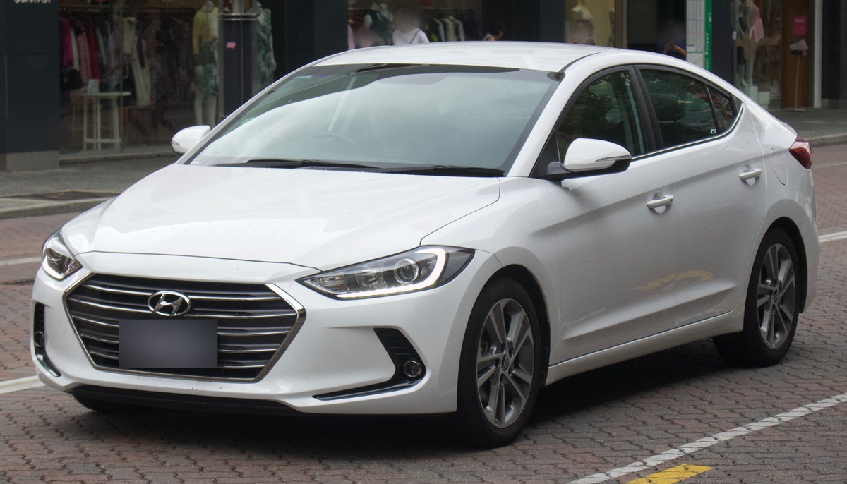 Белая Hyundai Elantra AD седан, вид спереди справа, на городской улице
