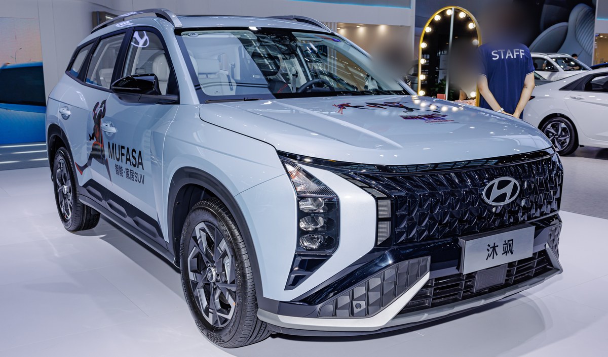 Светло-голубой Hyundai Mufasa на выставке, вид спереди в три четверти