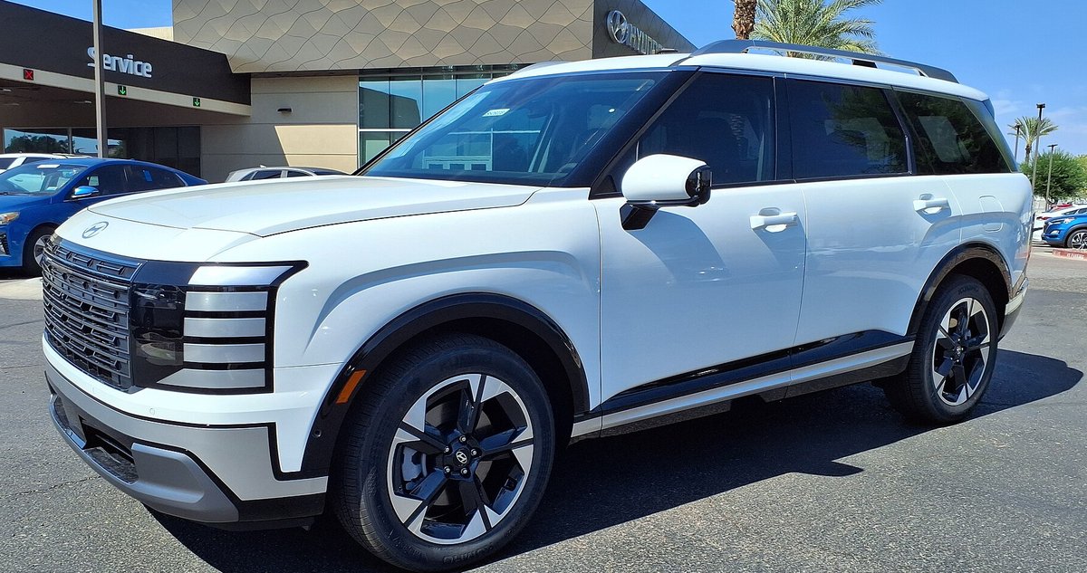 Белый Hyundai Palisade второго поколения на стоянке дилера, вид спереди