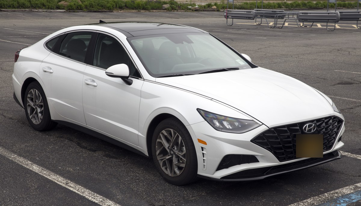 Белая Hyundai Sonata DN8 SEL, вид спереди справа, на пустой парковке