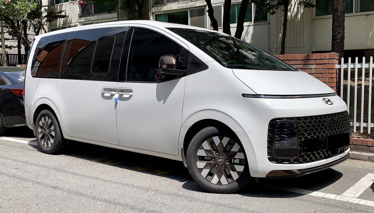 Белый Hyundai Staria, вид спереди в три четверти, на городской парковке
