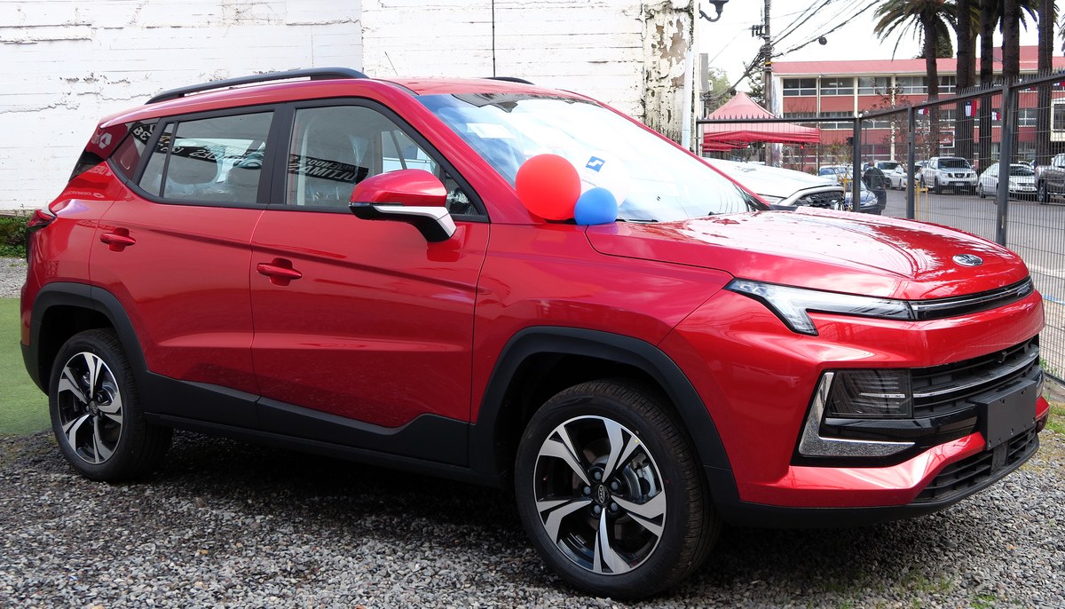 Красный компактный кроссовер JAC JS4, вид спереди справа в три четверти, на стоянке