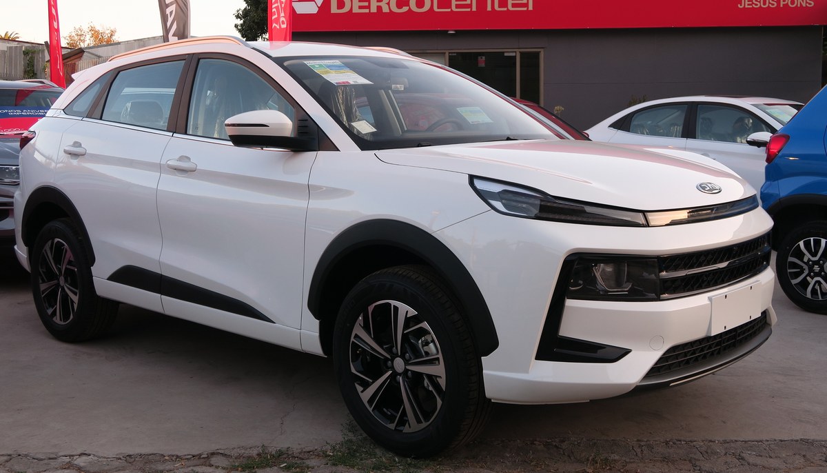 Белый кроссовер JAC JS6, вид спереди справа в три четверти, на площадке дилерского центра