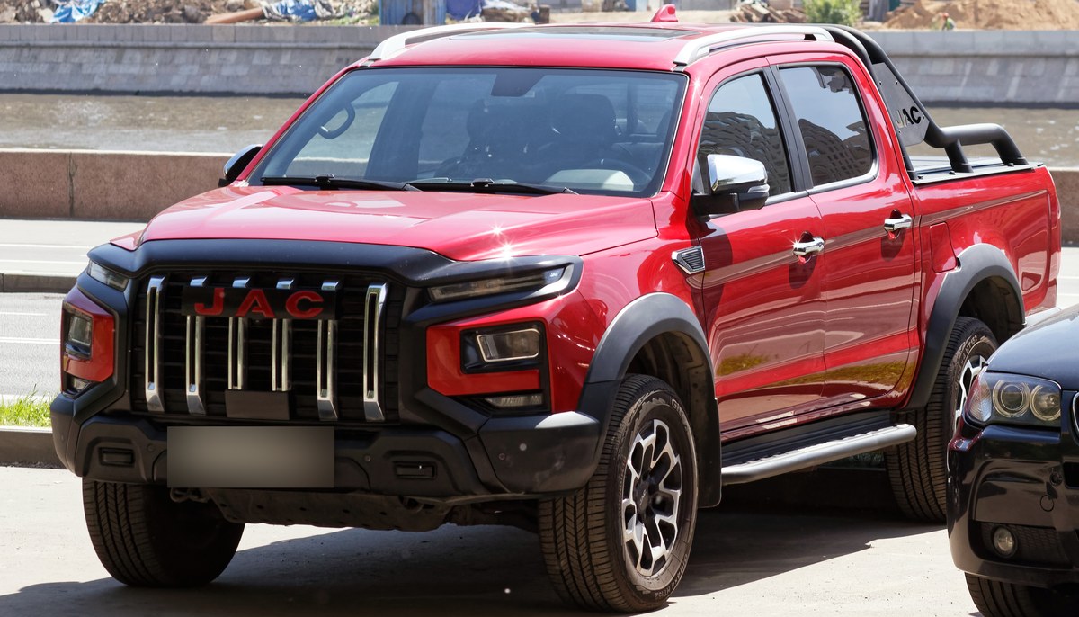 Красный пикап JAC T9, вид спереди и сбоку, на набережной в Москве