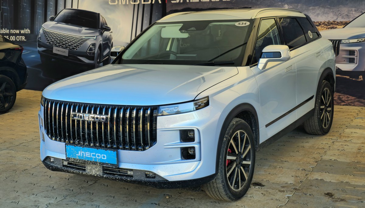 Светло-голубой Jaecoo J7 на выставке под открытым небом, вид спереди сбоку