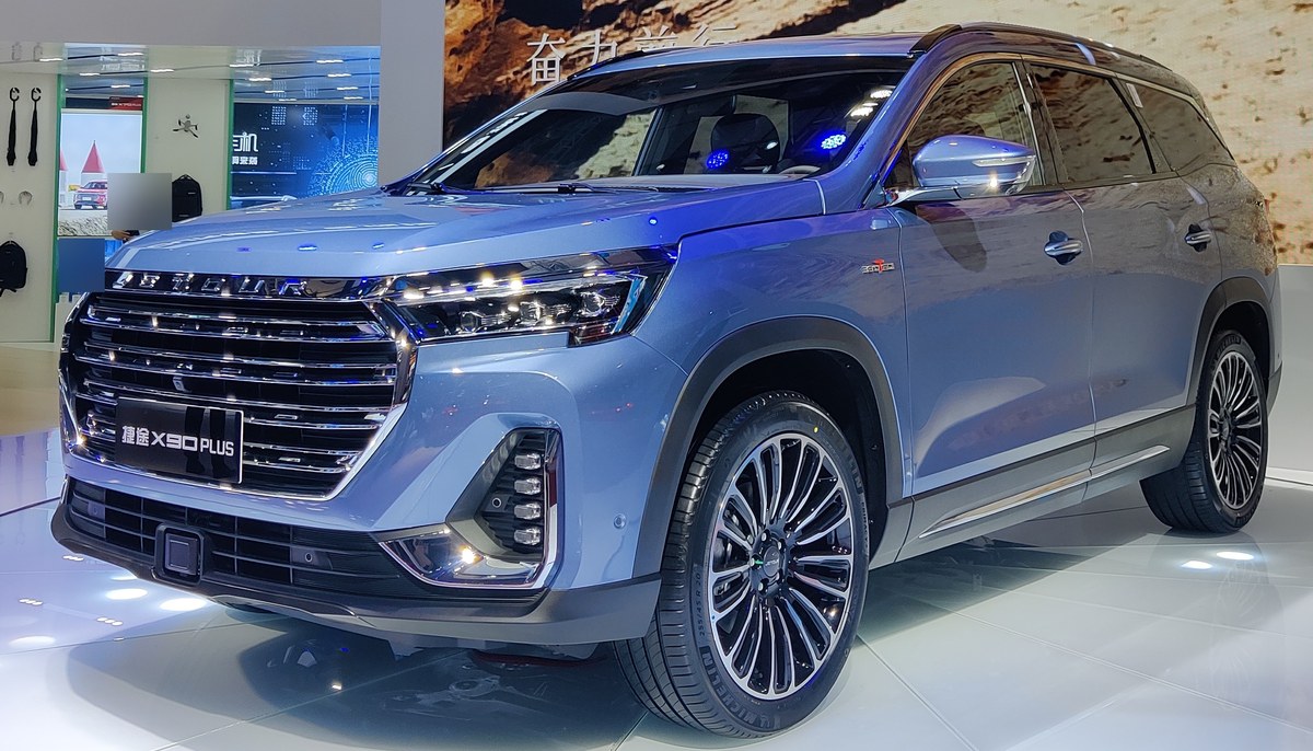 Голубой кроссовер Jetour X90 Plus на выставочном стенде, вид спереди слева