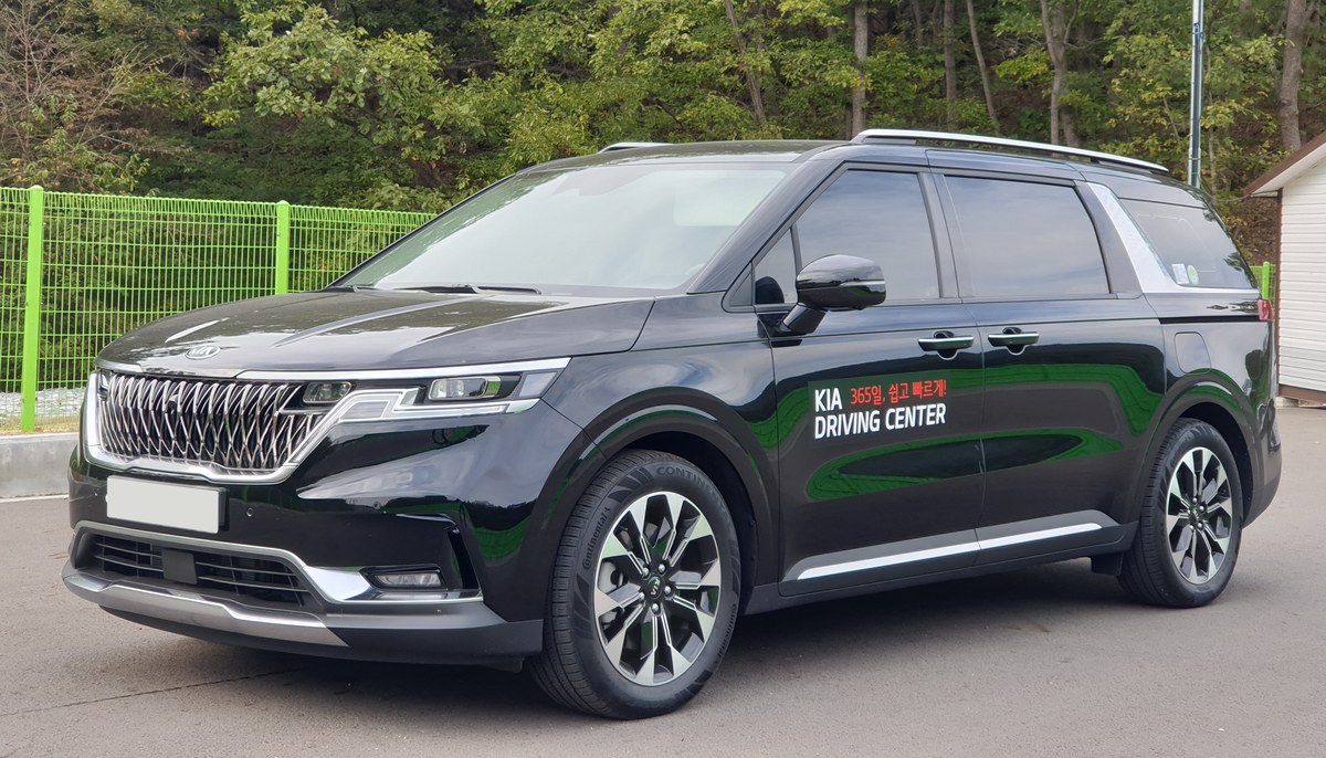 Чёрный минивэн Kia Carnival четвёртого поколения (KA4), вид спереди в три четверти