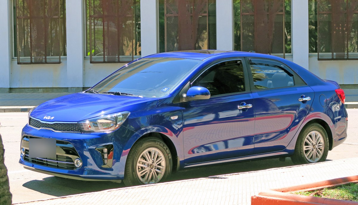 Синий седан Kia Soluto 2025 года, вид спереди в три четверти
