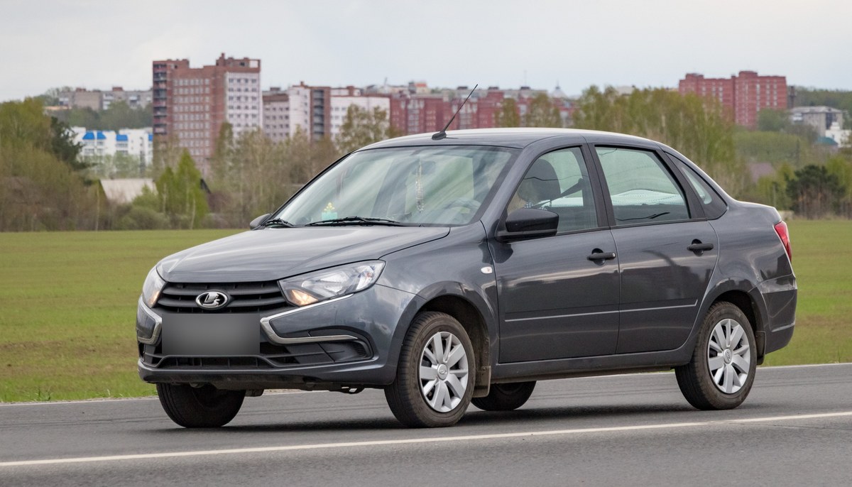 Серый седан Lada Granta после рестайлинга 2018 года, вид спереди сбоку, на дороге в Томске