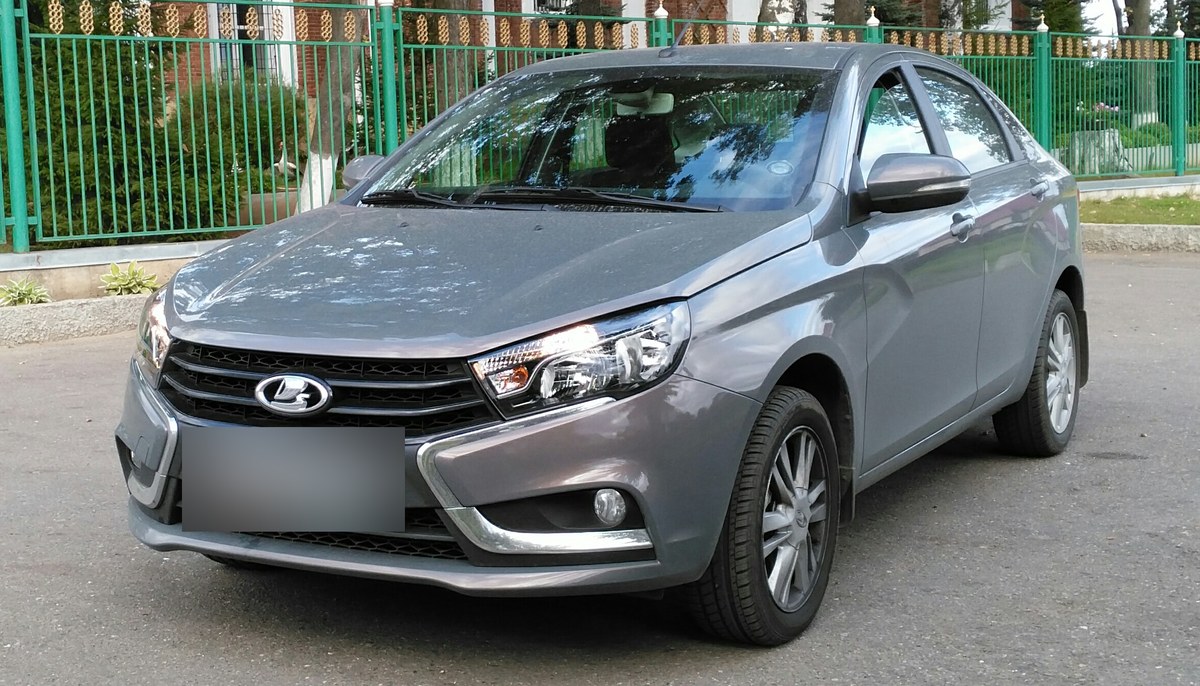 Серая Lada Vesta первого поколения, седан, вид спереди три четверти