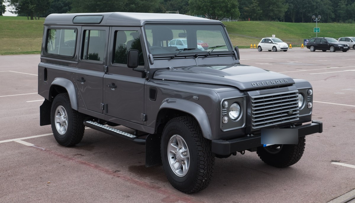 Серый Land Rover Defender 110 Station Wagon старого поколения, вид спереди справа в три четверти