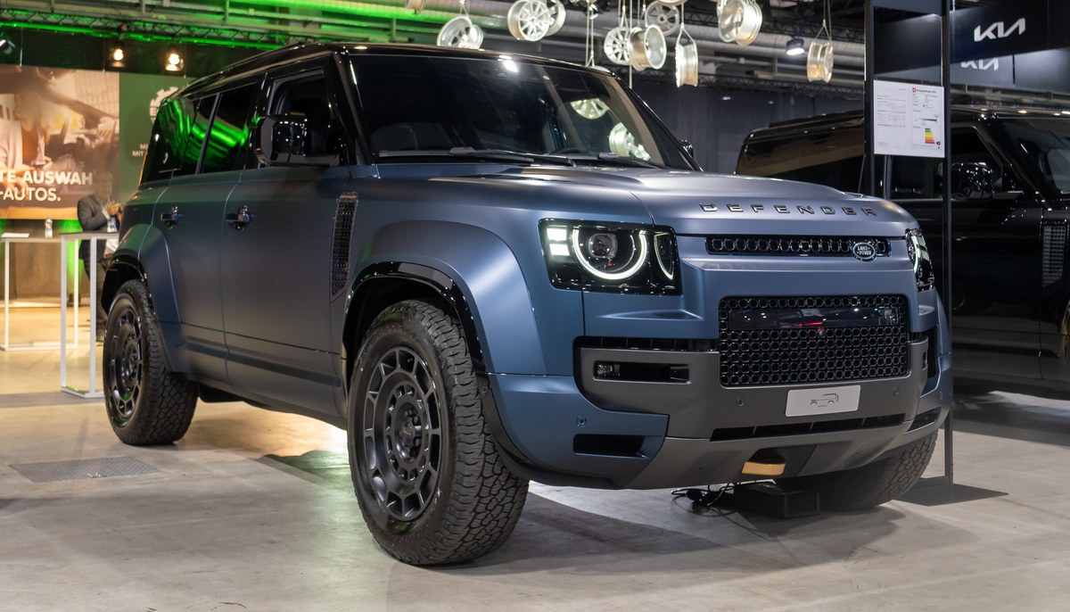 Синий Land Rover Defender 110 OCTA, вид спереди справа в три четверти, на выставочном стенде