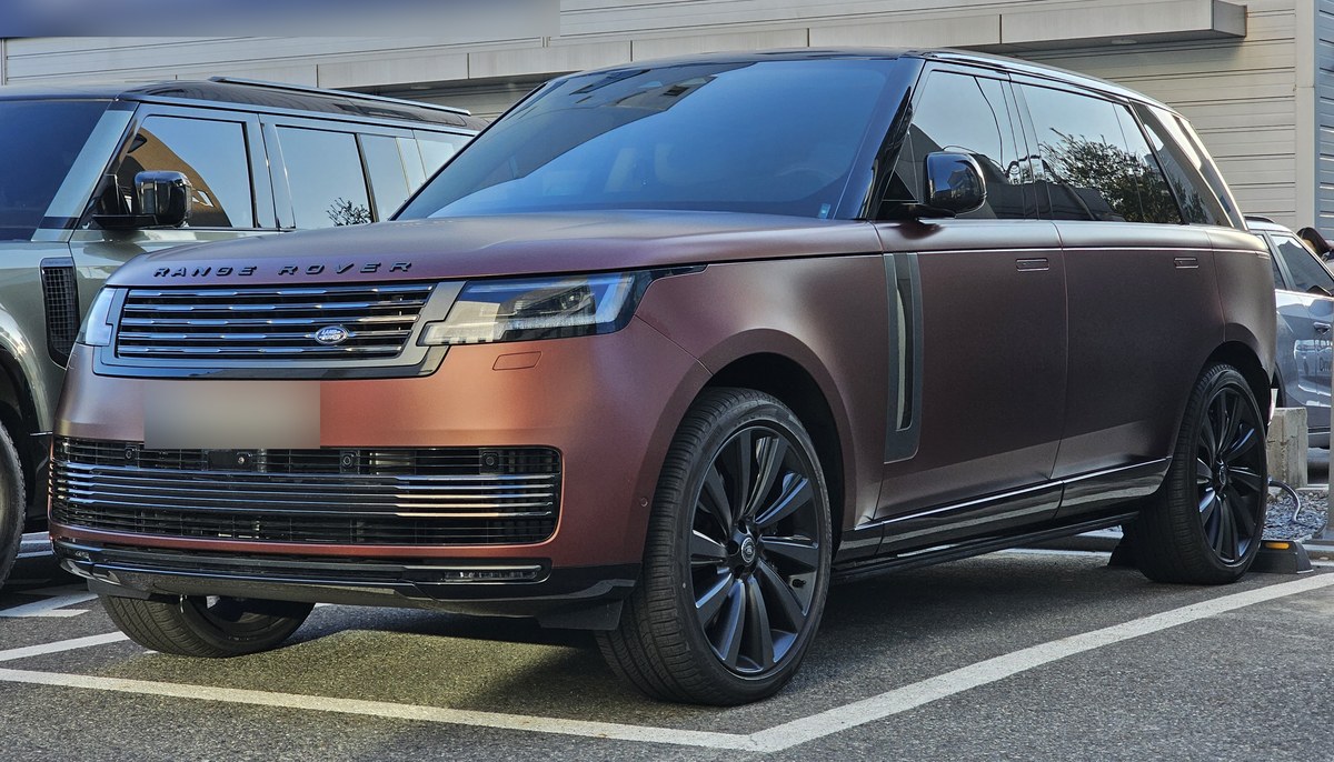 Range Rover L460 SV в матовом медно-коричневом цвете, вид спереди в три четверти, на парковке дилерского центра в Корее