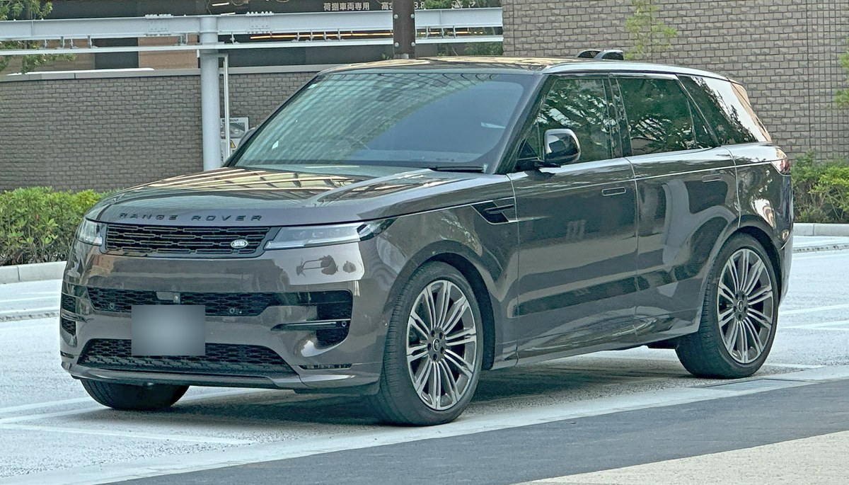 Серый Range Rover Sport третьего поколения (L461), вид спереди в три четверти, на городской парковке в Японии