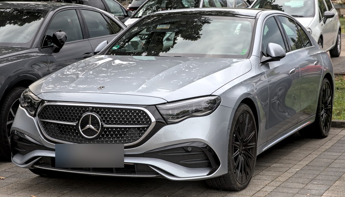 Серебристый Mercedes-Benz E-Class W214 седан, вид спереди в три четверти, на парковке