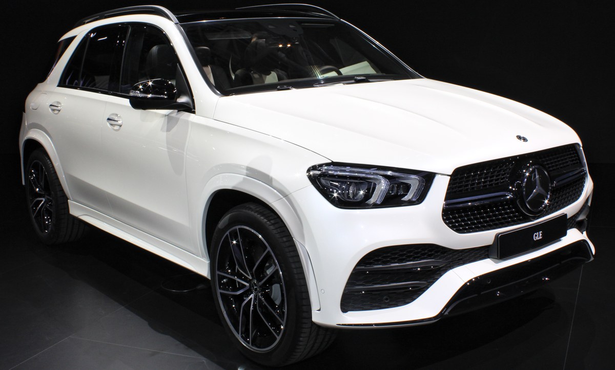 Белый Mercedes-Benz GLE V167 на выставочном стенде, кроссовер, вид спереди в три четверти
