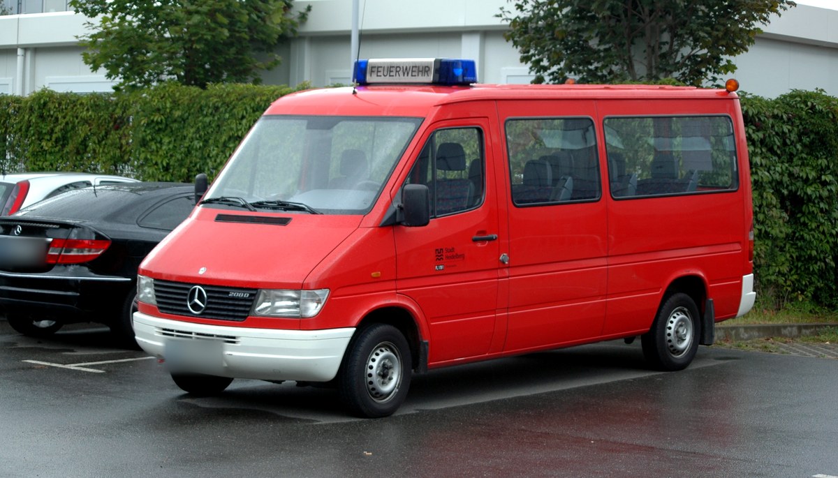 Красный Mercedes-Benz Sprinter 208 D первого поколения, микроавтобус пожарной службы, вид спереди слева в три четверти, на парковке