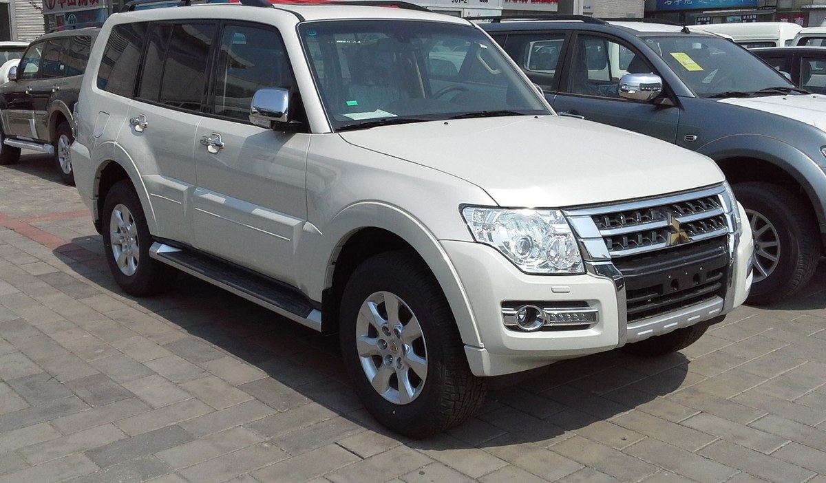 Белый Mitsubishi Pajero четвёртого поколения после рестайлинга, вид спереди сбоку