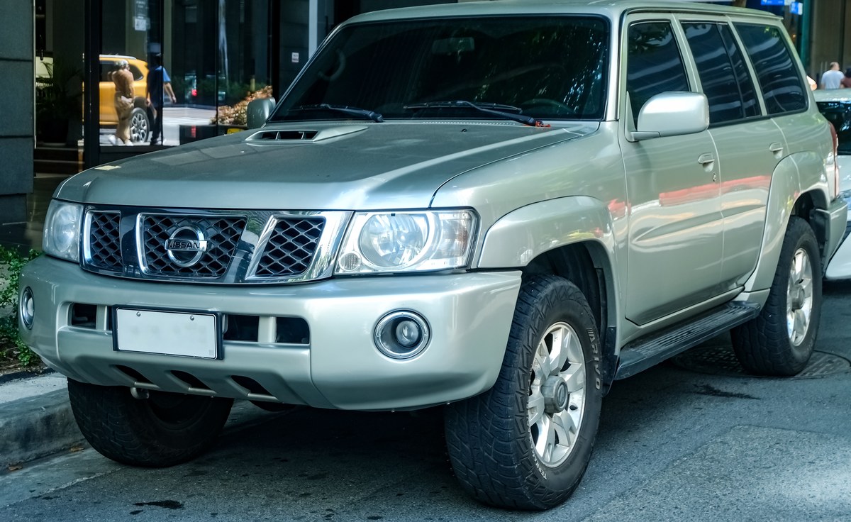 Серебристый Nissan Patrol Y61 с видом спереди сбоку, внедорожник на городской улице