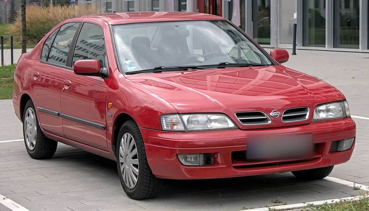 Красный Nissan Primera второго поколения (P11), седан, вид спереди в три четверти