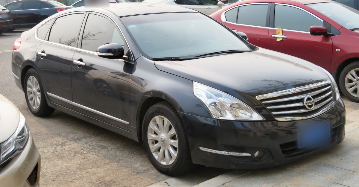Тёмно-серый Nissan Teana второго поколения (J32), седан, вид спереди в три четверти, на парковке