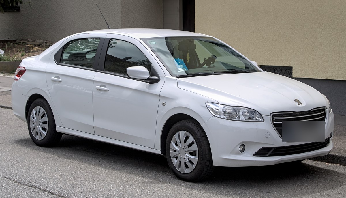 Белый седан Peugeot 301 первого поколения на стальных дисках, вид спереди сбоку